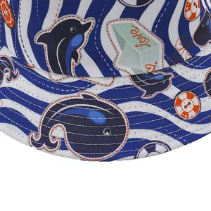Reversible bucket hat featuring blue dolphin and whale ocean prints on cotton fabric
