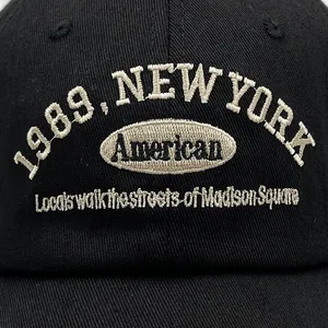 Detailed close-up of American 1989 embroidery on the black cotton baseball cap fabric