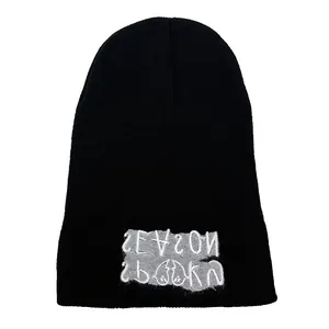 Black knit beanie with spooky season embroidery on a grey patch for winter warmth