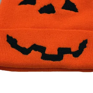 Orangefarbene Strickmütze mit schwarzer Halloween-Kürbis-Stickerei für kalte Tage