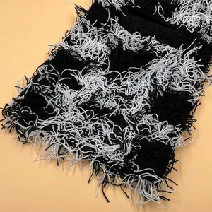 Close-up of black and white knitted fringe texture on camo balaclava beanie hat