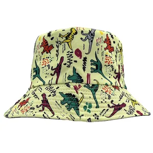 Detail of light yellow bucket hat fabric featuring colorful cartoon dinosaur prints