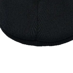 Macro shot of black knitted beanie texture showing high-quality stitching and fabric