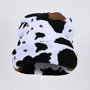Close-up of cow print knit beanie showing detailed texture and fold-over cuff design