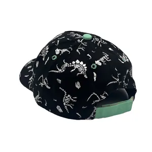 Detail of kids baseball cap with white dinosaur skeleton prints and mint green strap