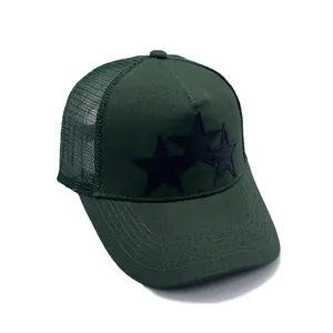 Gorra trucker de malla verde oscuro con tres parches de estrellas negras en fondo blanco