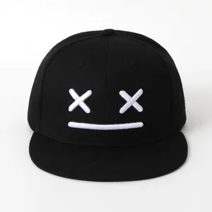 Cappellino snapback hip-hop nero con ricamo emoji bianco su sfondo neutro e minimale