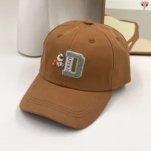 Détail macro de casquette marron en coton avec broderie ours dinosaure en 3D