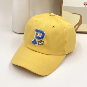 Détail de casquette de baseball jaune en coton avec broderie lettre P et motif chiot