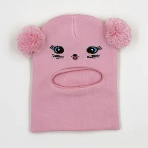 Close-up of pink knit balaclava with cute cat face embroidery and twin fluffy pom-poms