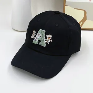 Vue détaillée de la casquette de baseball noire avec lettre A verte et broderie d'ours