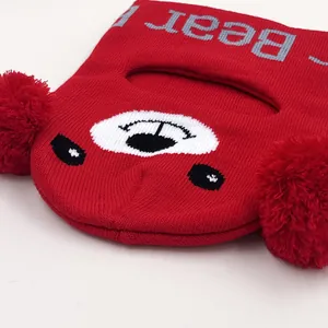 Passamontagna in maglia rossa per bambini con viso di orso, testo grigio e pompon morbidi
