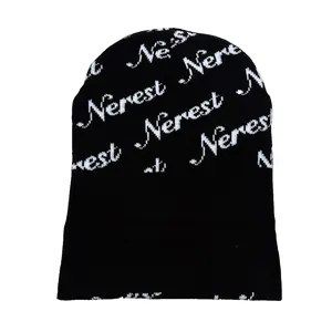 Détail du bonnet en maille Nerest avec lettrage jacquard blanc sur tissu noir chic
