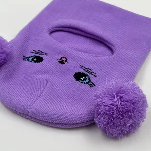 Purple knitted balaclava for kids with cute cat face design and large double pom-poms