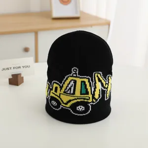 Kids black knitted beanie with cute yellow excavator pattern on a white surface