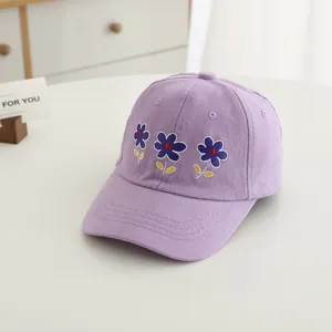 Close-up of lavender cotton baseball cap with detailed blue flower embroidery and stitching