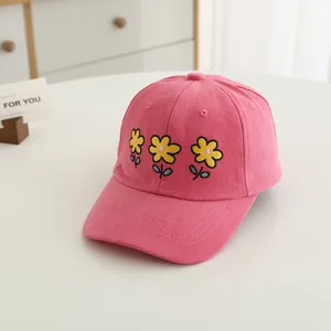 Close-up of three yellow flower embroidery on rose pink twill cotton baseball cap