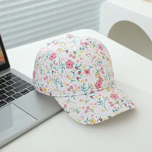 Detailed close-up of a floral cotton baseball cap with pink flower and cherry prints