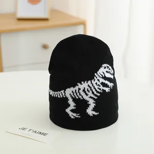 Close-up of black knit beanie for kids featuring a white dinosaur skeleton pattern