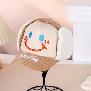 Detail der Kinder Wintermütze aus Cord mit Plüsch-Ohrenklappen und Smile-Stickerei-Motiv