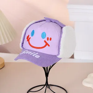 Detail der lila Wintermütze mit gestepptem Stoff, Fleece-Ohrenklappen und Smile-Stickerei