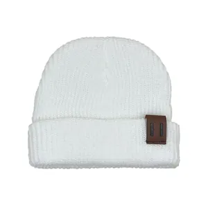 Detailed view of white knitted beanie featuring ribbed texture and brown leather patch