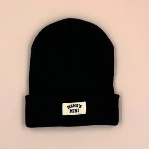 Black knitted winter beanie for toddlers with MAMA'S MINI patch on the folded brim