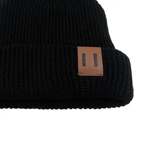 Classic black knitted beanie for kids with ribbed texture and brown leather patch accent