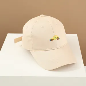 Détail d'une casquette en coton beige avec broderie de voiture jaune et texture fine