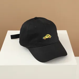 Détail de la broderie de voiture jaune sur la casquette de baseball noire pour enfants
