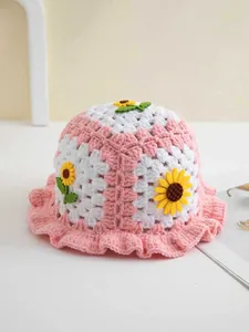 Detail eines rosa gehäkelten Fischerhuts mit gelben Sonnenblumen und Wellenrand für Kinder