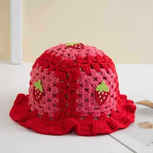 Dettaglio del cappello pescatore all'uncinetto rosso e rosa con ricamo a fragola