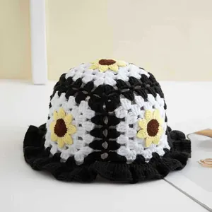 Dettagli della trama all'uncinetto del cappello a secchiello con girasole e tesa a balze