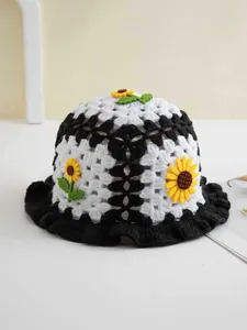 Detail eines handgehäkelten Sonnenblumen-Fischerhutes mit schwarz-weißem Strickmuster