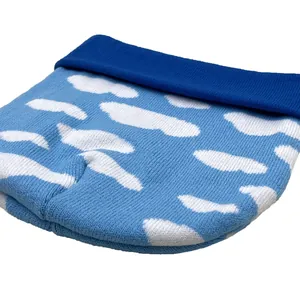 Dettaglio macro del cappello in maglia morbida con motivo jacquard a nuvole blu invernali