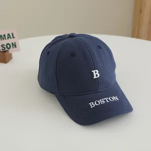 Détail de la casquette enfant bleu marine avec broderie Boston blanche et texture en coton