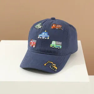 Dettaglio cappellino bambino blu navy con ricami di veicoli su piedistallo bianco