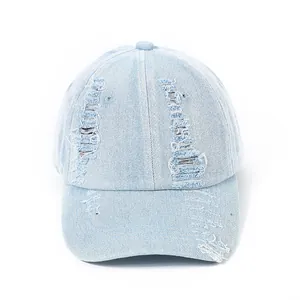 Close-up detail of vintage distressed denim baseball cap with frayed holes and worn texture