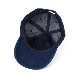 Detail of blue denim baseball cap showing interior stitching and metal back buckle