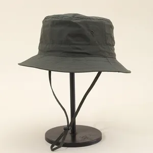 Detail of waterproof olive green bucket hat with adjustable windproof cord on metal stand