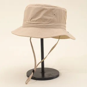 Waterproof outdoor bucket hat in beige with adjustable chin strap and wide reinforced brim