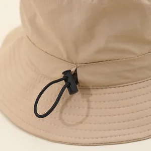 Waterproof outdoor bucket hat in khaki with adjustable drawstring and spring toggle detail