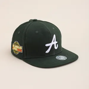 Detailed close-up of premium green baseball cap with white 3D embroidery and side patch