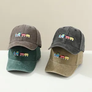 Detail of four washed cotton baseball caps with colorful train embroidery in various colors