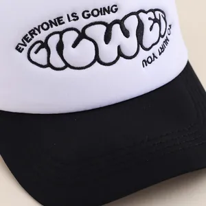 Front view of black and white trucker hat featuring text print and fine brim stitching