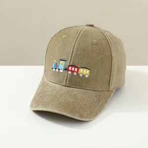 Kids khaki washed cotton baseball cap with colorful train embroidery on a studio stand