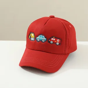 Gros plan détaillé d'une casquette rouge pour enfant avec broderie de voitures