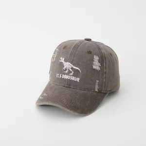 Detail of washed cotton baseball cap with dinosaur skeleton embroidery and distressed holes