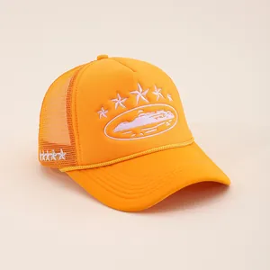 Detail of orange trucker hat featuring high-quality white star embroidery and breathable mesh