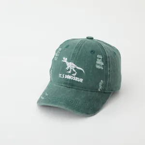Detailed embroidery of dinosaur skeleton on dark green distressed cotton baseball cap